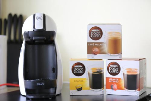 eine Kaffeemaschine und eine Schachtel Kaffeetassen in der Unterkunft Modern 2 Rooms Apartment in Kaunas