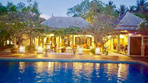 a swimming pool in front of a house at Bhumlapa Garden Resort in Bophut