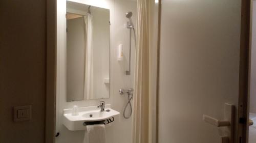 a bathroom with a sink and a mirror at Hôtel le Pastel in Toulouse