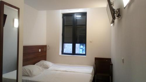 a bedroom with two beds and a window at Hôtel le Pastel in Toulouse