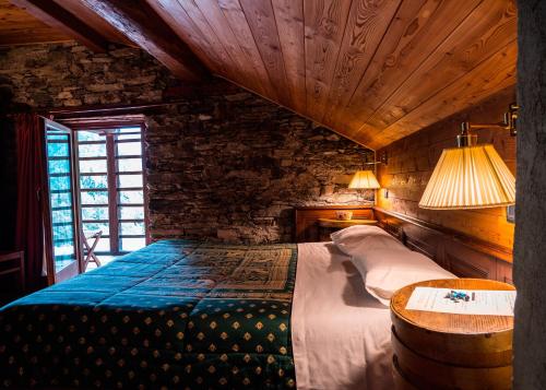 a bedroom with a bed and a table in a room at Albergo Montagna Di Luce in Alagna Valsesia