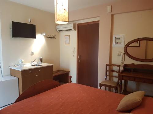 a room with a table and a kitchen with a sink at Yiannis Apartments in Ioannina