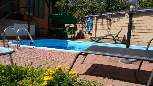 una pequeña piscina con un banco al lado en Pension Tip-Top, en Târgu Mureș