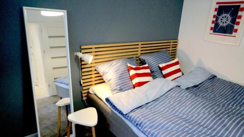 ジブヌベクにあるPorta Mare No12のベッドルーム1室(赤と白の枕が備わるベッド1台付)
