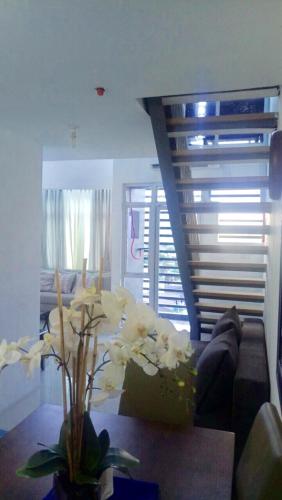 a living room with a couch and a table with flowers at Affordable Makati APT in Manila