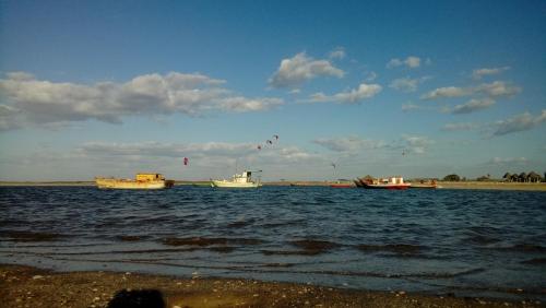 three boats in the water with kites in the sky at Pousada Theodora in Macapá