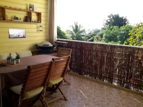 a patio with a table and chairs and a fence at Chambre d'Hôte Ti coin Tranquille in Saint-Leu