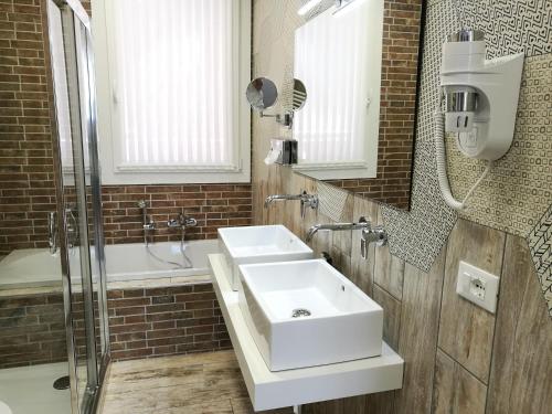 a bathroom with a white sink and a shower at Residence Eleonora in Sottomarina
