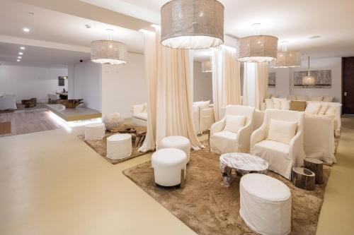 a large living room with white chairs and a couch at Lagos Avenida Hotel in Lagos