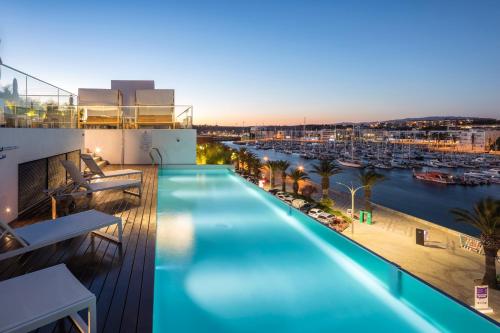 a swimming pool on the roof of a building with a harbor at Lagos Avenida Hotel in Lagos