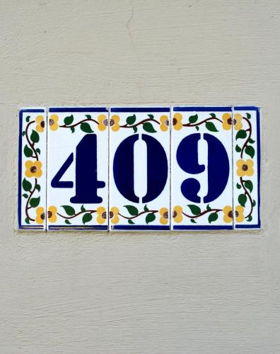 a blue and white sign on a wall with flowers at Villa Letná in Brandýs nad Labem-Stará Boleslav