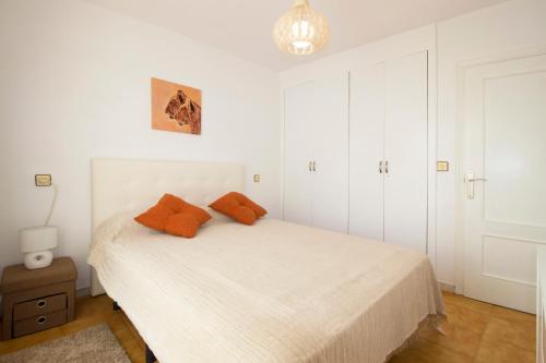 a bedroom with a bed with orange pillows on it at Espanatour Calas Blancas in Torrevieja
