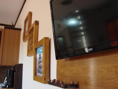 a flat screen tv hanging on a wall with a cross at AnnaDes Apartments & Studios Chios in Karfas