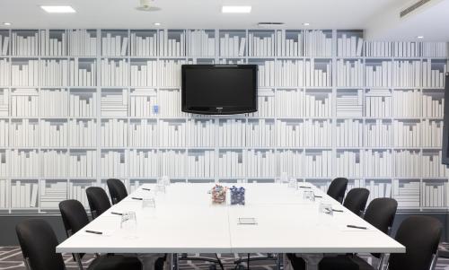 a conference room with a table and a tv on a wall at Village Hotel Warrington in Warrington