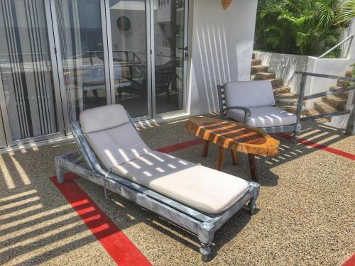two chairs and a bench sitting on a porch at Villa Aikia (Adults Suites A/C) in Zipolite