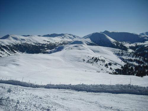 a snow covered mountain with mountains in the background at Lärchenhof Apartment Nr 8 in Innerkrems