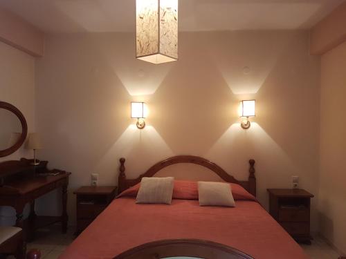 a bedroom with a bed and two lights on the wall at Yiannis Apartments in Ioannina
