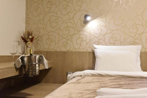a bedroom with a bed and a table with wine glasses at Garni Hotel Mlinarev san in Arilje