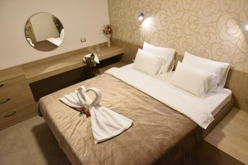 a hotel room with a bed with a towel on it at Garni Hotel Mlinarev san in Arilje