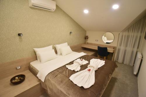 Arilje的住宿－Garni Hotel Mlinarev san，一间卧室配有一张大床和毛巾