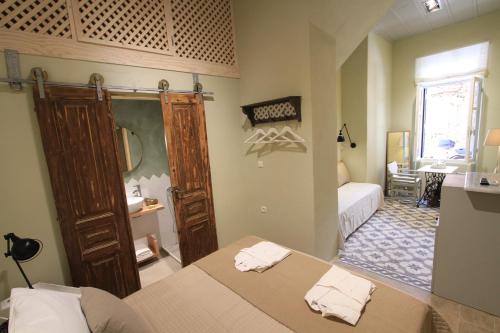 una camera con letto e un bagno con specchio di Fagotto Art Residences a Chania