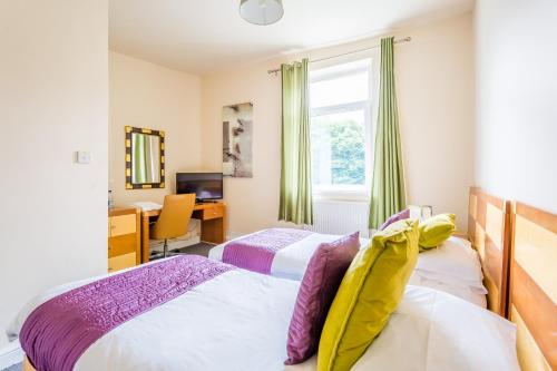 1 dormitorio con 2 camas, escritorio y ventana en Dunraven Hotel, en Rhondda