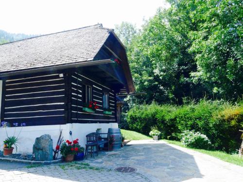 ein kleines Haus mit schwarz-weiß in der Unterkunft Bachkeusche in Ossiach