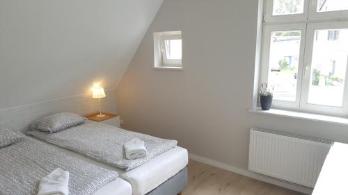 Un dormitorio blanco con una cama y una ventana. en Apartamenty Marina by Manage Rent, en Ustka
