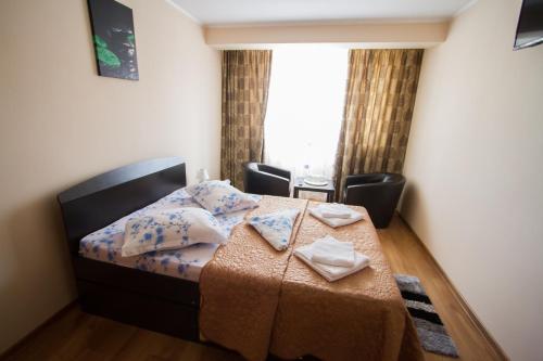 a bedroom with a bed with a table and a window at Casa Mara in Tulcea