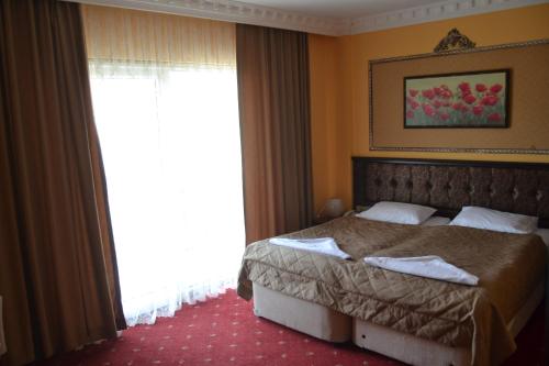 a bedroom with a bed and a large window at Hotel Deniz Eceabat in Eceabat