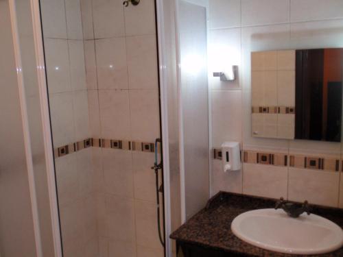 a bathroom with a sink and a shower with a mirror at Hotel Deniz Eceabat in Eceabat