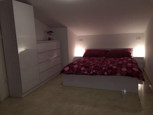 a bedroom with a bed with red sheets and red pillows at Dux Solo in Vinišće