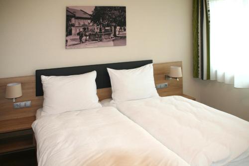 un letto con due cuscini bianchi sopra di Hauerwirt a Sankt Peter am Wimberg
