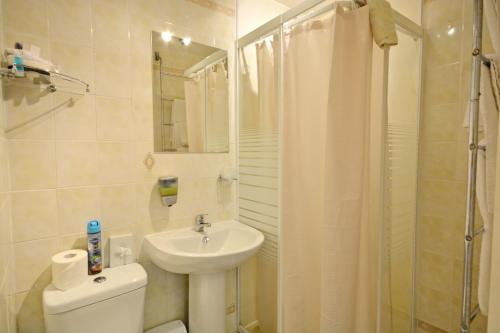 a bathroom with a toilet and a sink and a shower at The Astor Hotel in Blackpool