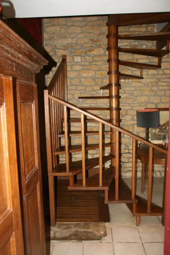 a wooden staircase in a room with a brick wall at Le Gite Du Breux Face Semois Chassepierre au 2 ème étage in Chassepierre