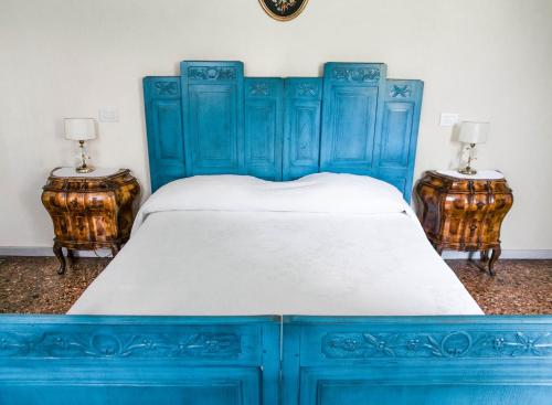 a blue bed with blue cabinets and two end tables at Villa Fava in Montagnana