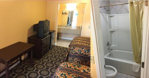 a hotel room with two beds and a tv and a tub at Leesville Lodge in Leesville