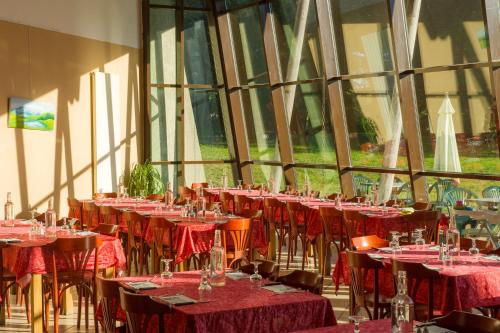 une pièce remplie de tables et de chaises avec un tissu de table rouge dans l'établissement VTF Le Domaine des Puys, à Saint-Sauves- dʼAuvergne