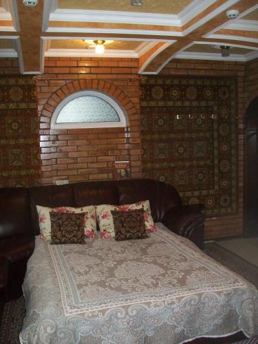 a bed in a room with a brick wall at atHome in Sumy