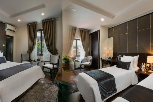 Cette chambre comprend deux lits et un bureau. dans l'établissement La Santé Hotel & Spa, à Hanoï