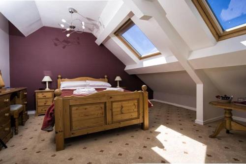 a bedroom with a bed and a ceiling with windows at The Ship Hotel in Aberdaron