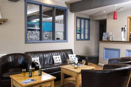 a restaurant with leather chairs and a table with wine glasses at The Ship Hotel in Aberdaron