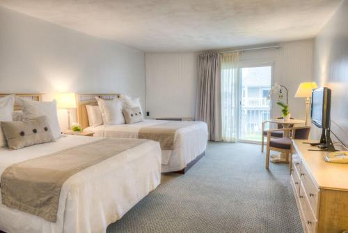 丹尼斯港的住宿－The Three Seasons Resort，酒店客房设有两张床和电视。