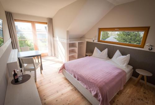 Schlafzimmer mit einem Bett, einem Tisch und einem Fenster in der Unterkunft SCHEIBER Wein & Gästehaus in Weiden am See