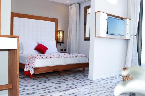 a bedroom with a bed and a flat screen tv at Yarden Estate Hotel in Yesod Hamaala