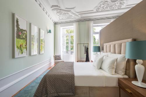 1 dormitorio con 1 cama con colcha blanca en Predicados do Douro Palace, en Oporto