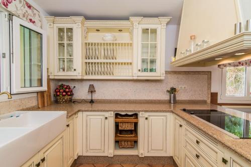 a kitchen with white cabinets and a sink at Benalmádena Coast Villa in Arroyo de la Miel