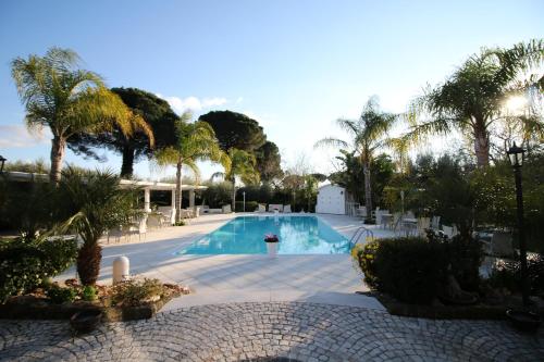 una piscina con palme e un resort di GaiaChiara Resort a Caserta