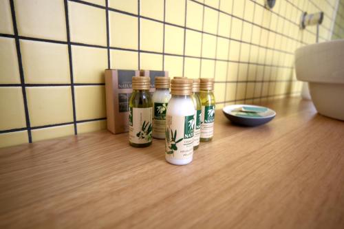 a group of four bottles sitting on a wooden floor at Napoliamo Guest House in Naples