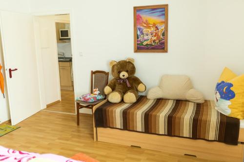 un osito de peluche sentado en una cama en una habitación en Ferienwohnung Schermer, en Rinteln